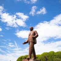 広島城跡に立つ池田勇人の銅像、歴史的記念碑と青空の写真