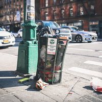 ニューヨークの街角に散乱するゴミとゴミ箱の写真