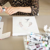 キャンバスを前に絵具パレットを用意する女性の写真