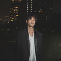 深夜に友人の男性と待ち合わせする街角での立ち姿の写真