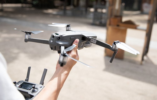 テーブルの上でドローンのコントローラーを握り、今からドローンを飛ばす準備
