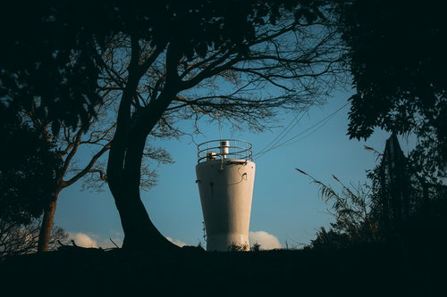 森影から見るコップのような物見台と青空の風景