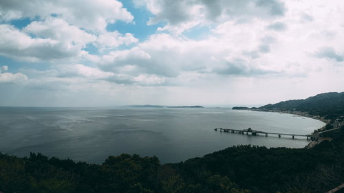 見晴らしのいい山から見下ろす海と工場と漁村の沿岸風景