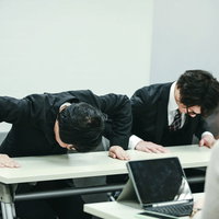 不祥事で謝罪する会社役員の記者会見の写真