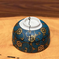 金継ぎで修復された紺色の花柄お椀、木製テーブルに置かれた和食器の写真