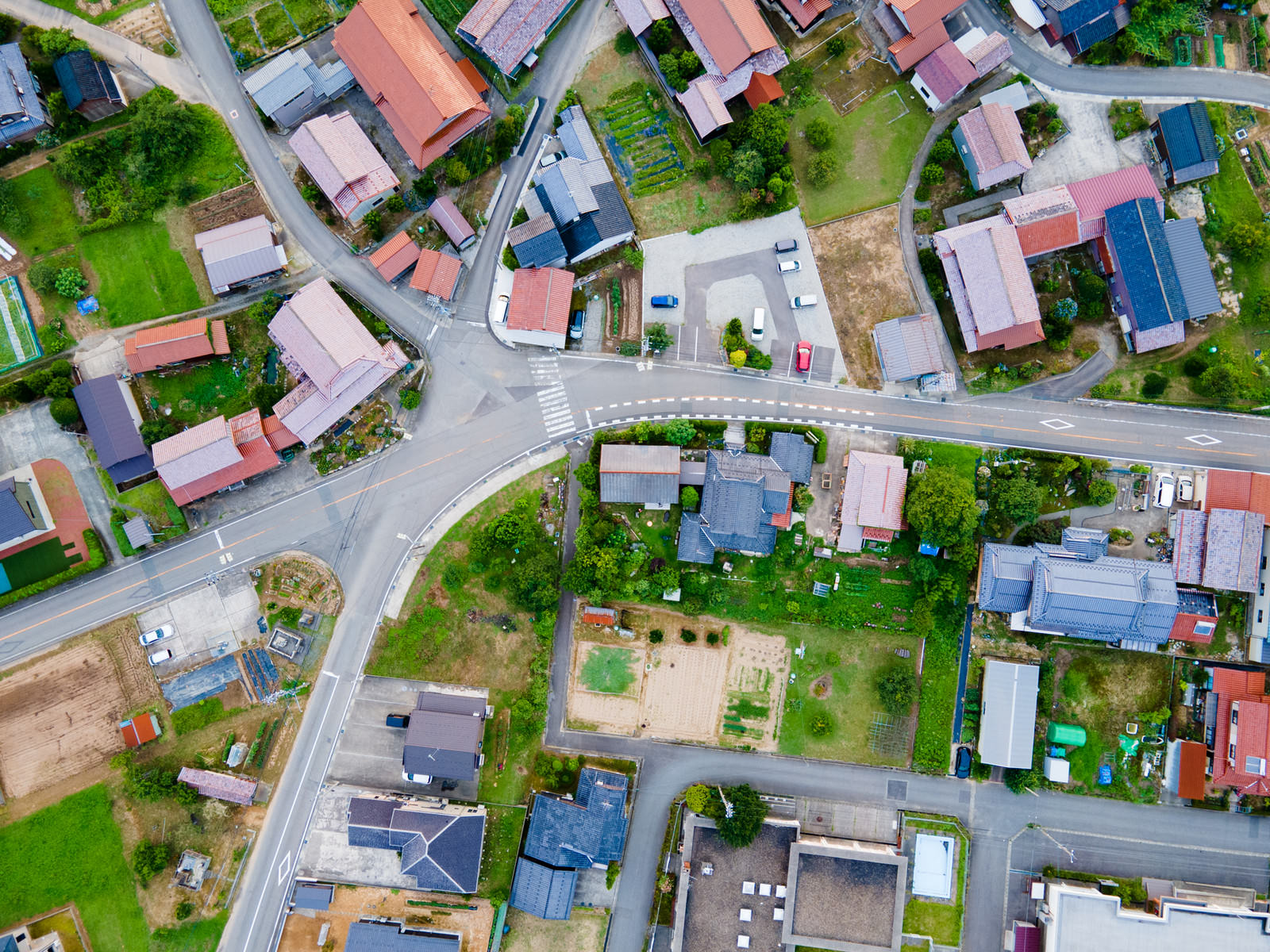 上空から撮影された住宅街の俯瞰写真。様々な色の屋根の住宅が立ち並ぶ