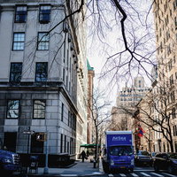 ニューヨークの街角に停まる配送トラックと歩道の風景の写真