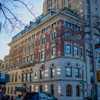 ニューヨークの街角に立つ煉瓦造りの建築物と横断歩道の写真