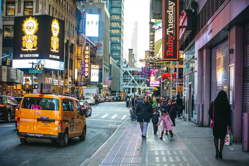 ニューヨークの横断歩道を行き交う観光客と電飾看板