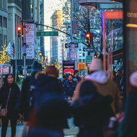 ニューヨークの繁華街に群れる観光客と夜景のビル街の写真