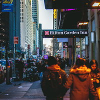 ニューヨーク繁華街の夜間歩道を行き交う観光客や通行人の賑わいの写真