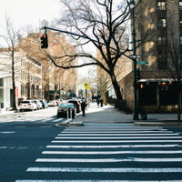 ニューヨークの街角で横断歩道の信号待ちをするビジネスマンの写真