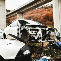フロント部分が激しく大破した事故車（廃車施設）の写真
