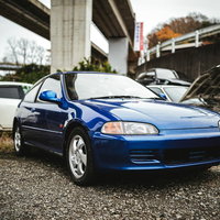 ナンバープレートが外された廃車工場の青い自動車の写真