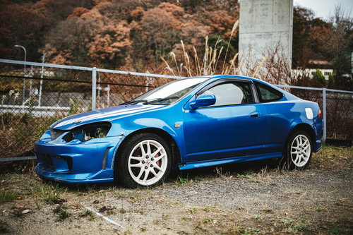 ヘッドライトが外された青い廃車のフロント部分