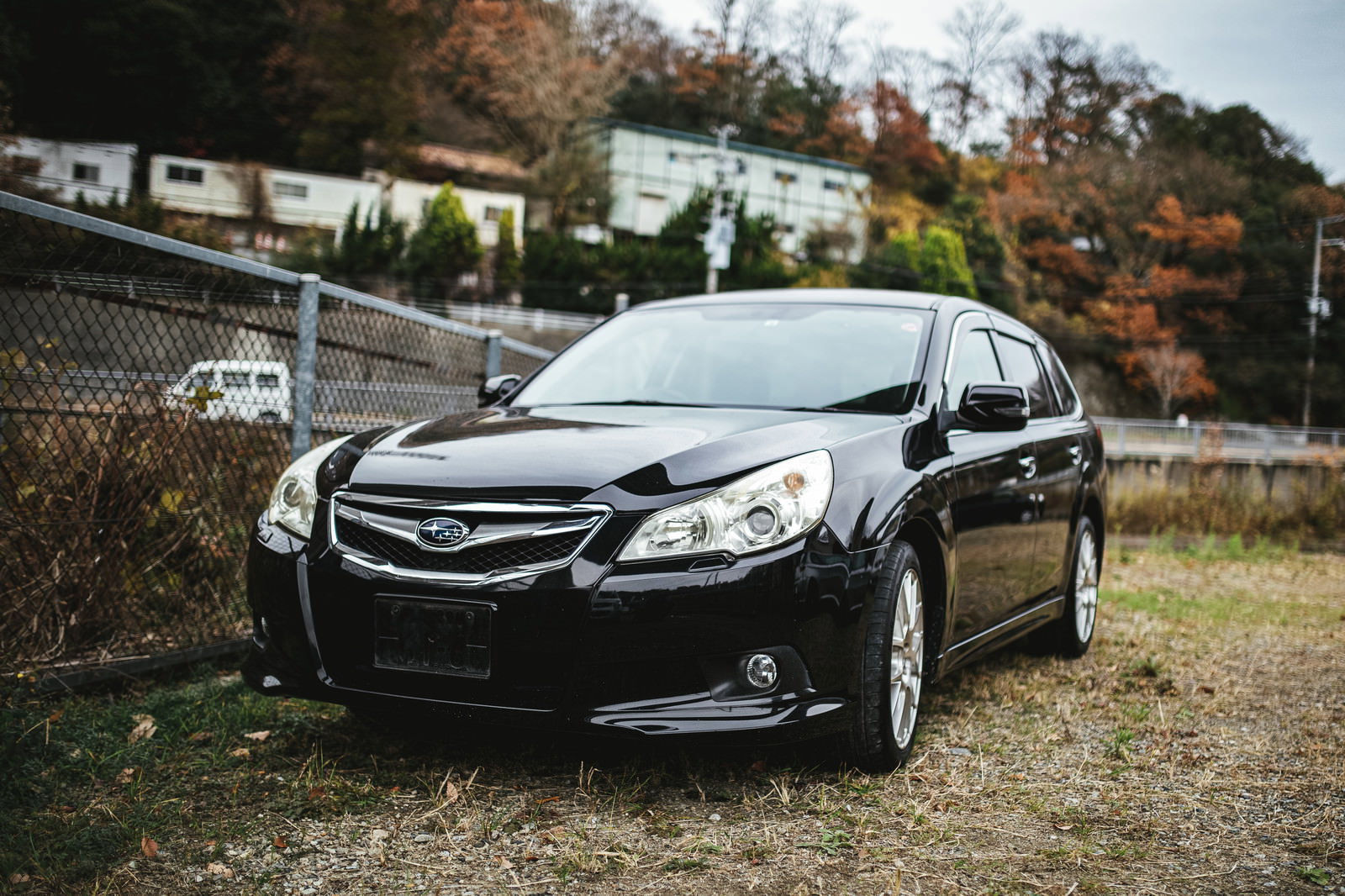 ナンバープレートを外した黒いセダンが駐車場に停車している