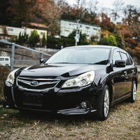 ナンバープレートを外した黒いセダン型の廃車の写真