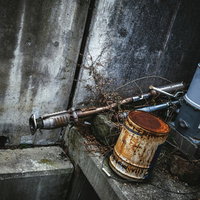 錆びた容器とパイプが並ぶ古い工場内の風景の写真