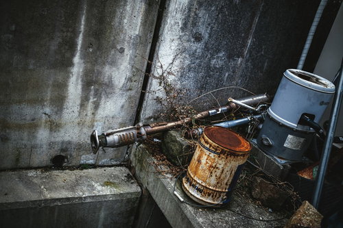 錆びた容器とパイプが並ぶ古い工場内の風景