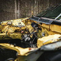 黄色いフレームのみ残された廃車の金属骨組みの写真