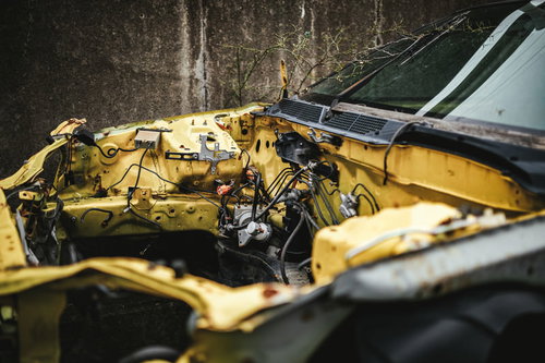 黄色いフレームのみ残された廃車の金属骨組み