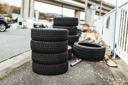 自動車整備工場に積み重ねられたスペアタイヤ