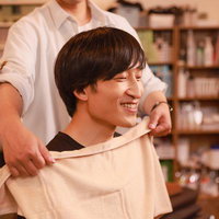落ち着いた雰囲気のサロン店内でリラックスした表情の男性の写真