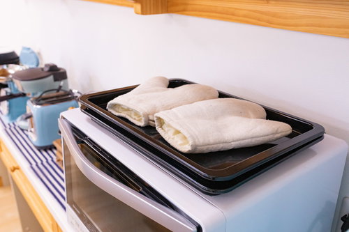 電子レンジの上に置かれたベージュ色のミトン（鍋つかみ）