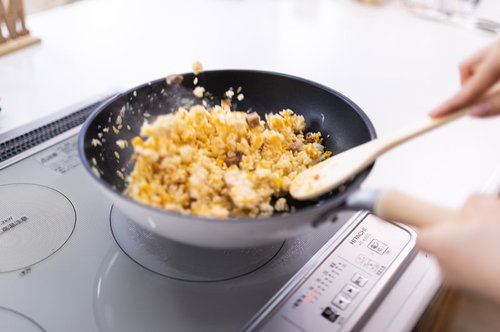 黒いフライパンでチャーハンを炒める手元の調理風景