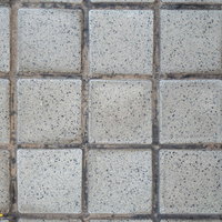 グレーの正方形石タイルが規則正しく並ぶ塀の写真