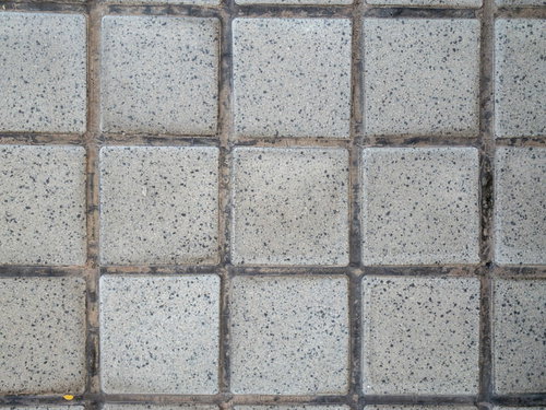 グレーの正方形石タイルが規則正しく並ぶ塀