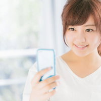 スマホで健康管理を行う意識の高い女性の笑顔の写真