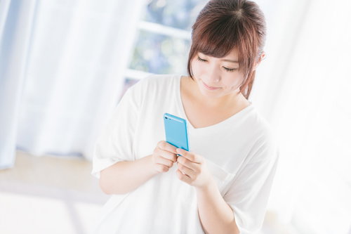 スマホで健康診断の結果を確認してご満悦の女性
