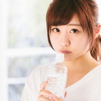 水分補給が欠かせないペットボトルを持つ女性の写真