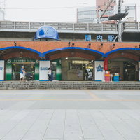 関内駅前の横浜スタジアム方向の駅舎正面と青いアーチ型の庇の写真