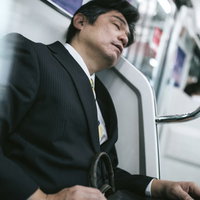 お父さん、毎日おつかれさま～電車で寝落ちするスーツ姿の中年男性の写真