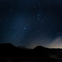 建物に絡み合う無数の電線と配管の写真