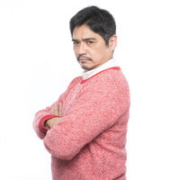 腕を組んで睨む激おこ父さん、ピンク色のざっくりセーター姿の中年男性の写真