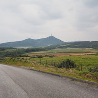 与那国島の広大な農地と山々を見渡す曇り空の田園風景の写真