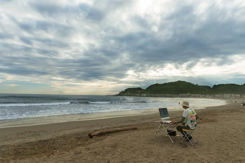 徹夜しすぎて浜辺でコーディングしているかの幻覚をみているWebデザイナー