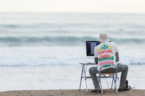 GW明け、締め切りの波が続々と海辺の浜辺に押し寄せるWebデザイナー