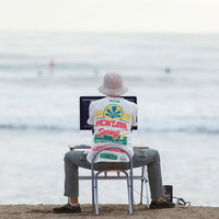 サーファーを眺めながら、サーファーのWebサイトを仕上げる意識の高いデザイナーの写真