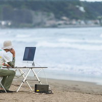 上司に「早く帰ってこい！」「すぐには帰れませんよ浜辺ですから」と正直に答えるWebデザイナーの写真