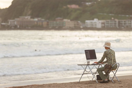 そろそろ終電だな、と焦るWebクリエイター　海岸での作業