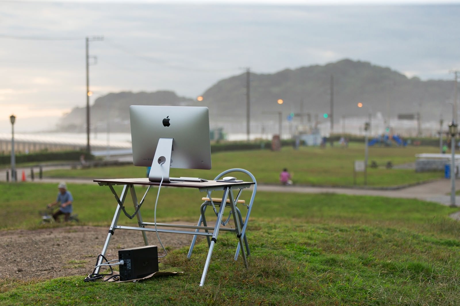 海沿いの公園の芝生の上に置かれたiMac