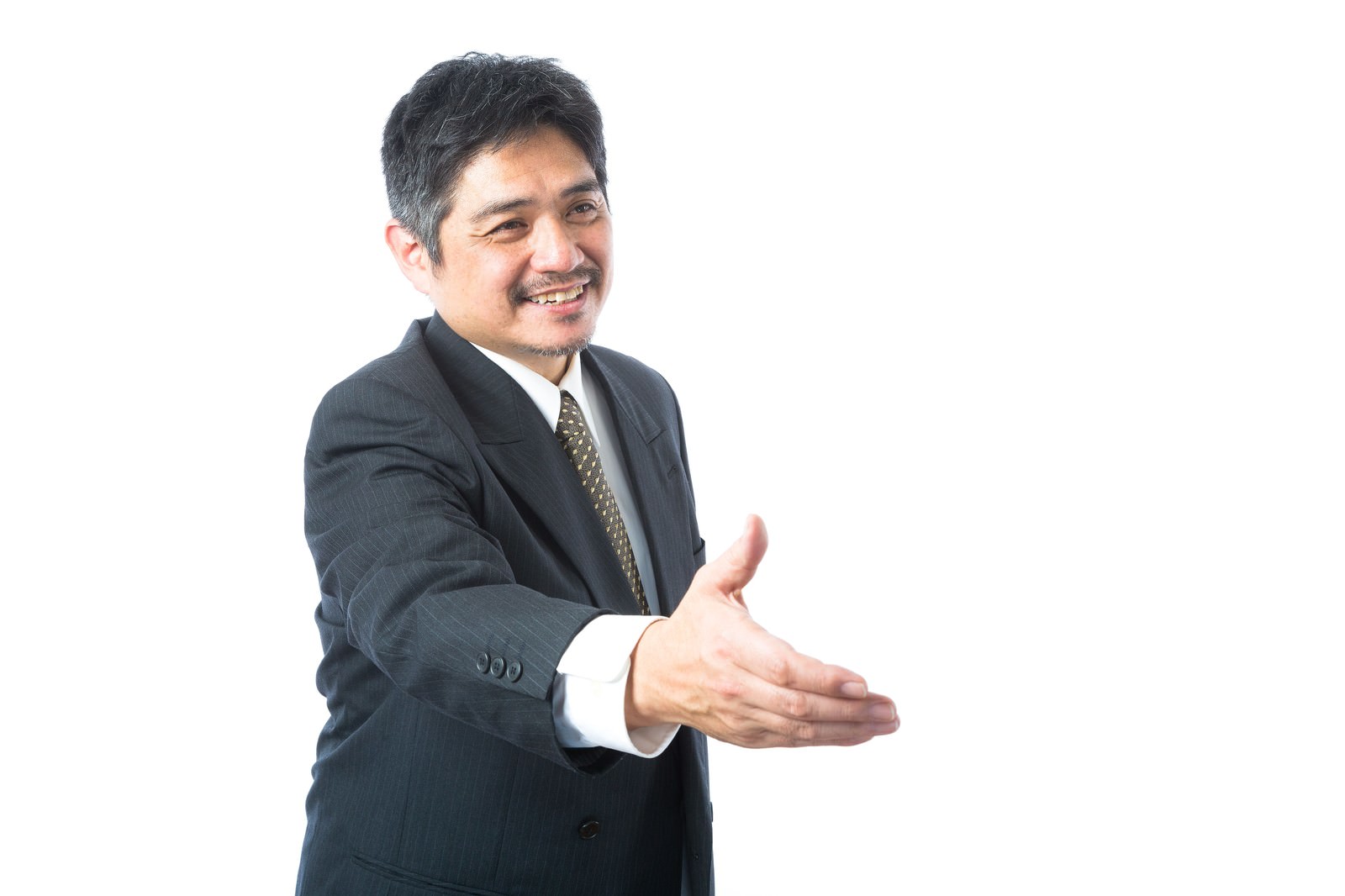握手を求める中年の営業部長がスーツ姿で笑顔を見せている［モデル：よたか］