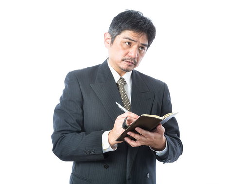 足を使い聞き込み捜査をするベテラン刑事、ノートにメモを取る