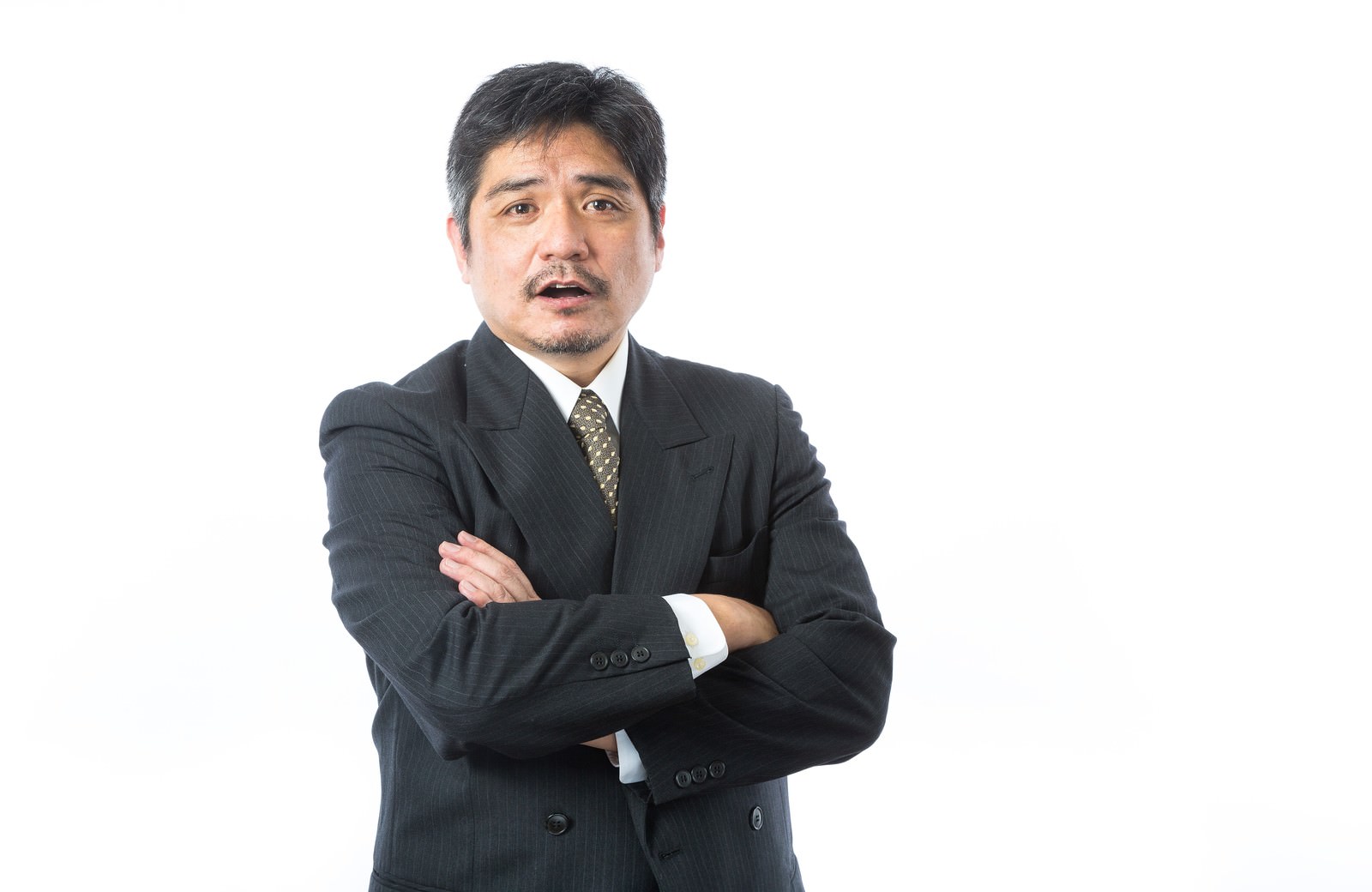 腕組みして驚いた表情の中年男性上司［モデル：よたか］