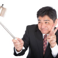 娘に教えてもらった自撮りで撮影する中年の上司の写真