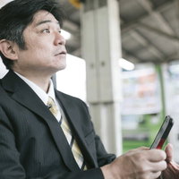 駅のベンチでスマホに熱中してて電車がいってしまった上司の写真